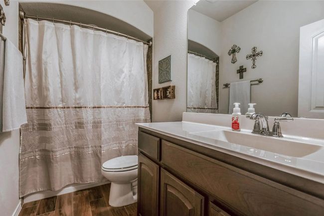Bathroom featuring a shower with curtain, vanity, toilet, and wood finished floors | Image 31