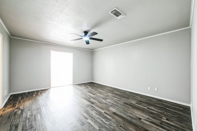 Unfurnished bedroom featuring visible vents, ceiling fan, baseboards, dark wood finished floors, and ornamental molding | Image 11