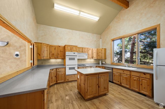 Clubhouse: Community Kitchen with a sink, white appliances, light wood-style floors, beam ceiling, and high vaulted ceiling | Image 39