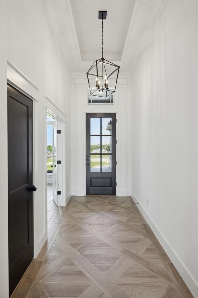 Entryway with a tray ceiling, a chandelier, and light parquet floors | Image 4