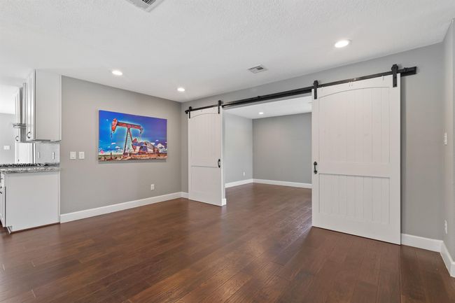 The dining room is just off the kitchen and has the continued engineered wood floors. This space is perfect for any size furniture. The rustic sliding barn doors open into the flex space. | Image 5