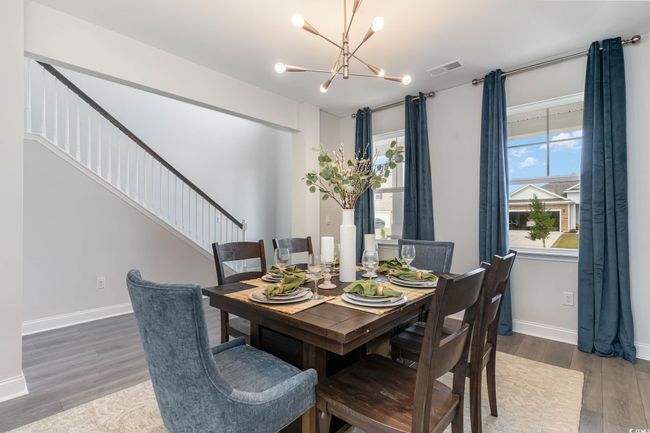 Dining area featuring a chandelier, stairs, and wood finished floors | Image 4