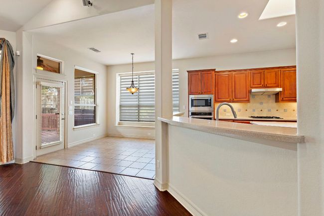 Kitchen with baseboards, visible vents, backsplash, light countertops, and appliances with stainless steel finishes | Image 10