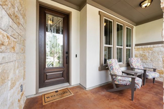 View of exterior entry featuring stone siding and a porch | Image 5