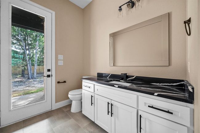 Bathroom with tile patterned flooring, vanity, toilet, and baseboards | Image 27