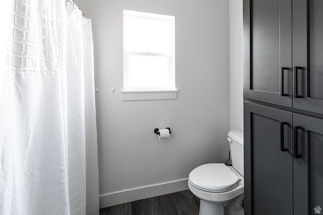 Bathroom featuring toilet, wood finished floors, and baseboards | Image 24