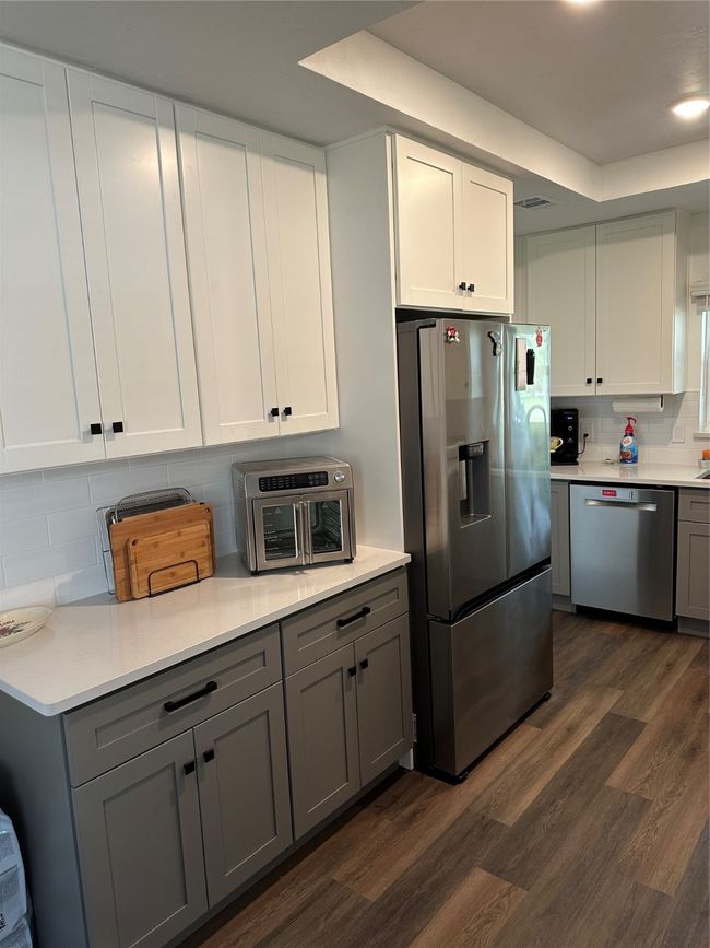 Kitchen with refrigerator, dishwasher, gray cabinets, and decorative backsplash | Image 8