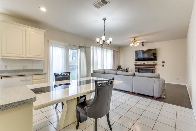 Dining area with recessed lighting, light tile patterned floors, ceiling fan with notable chandelier, baseboards, and visible vents | Image 11