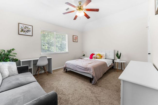 Bedroom with light carpet, baseboards, ceiling fan, and lofted ceiling | Image 24