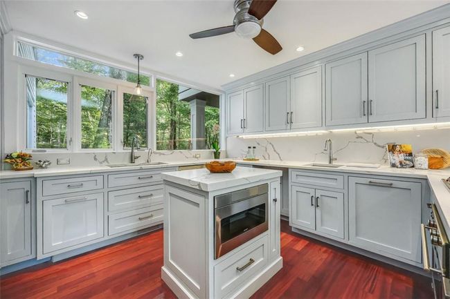 Kitchen with tasteful backsplash, dark hardwood / wood-style flooring, sink, ceiling fan, and stainless steel microwave | Image 9