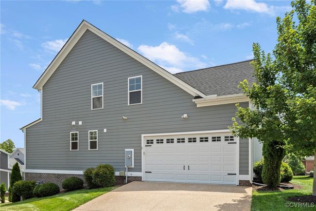 View of home's exterior featuring a garage, concrete driveway, roof with shingles, and a lawn | Image 46