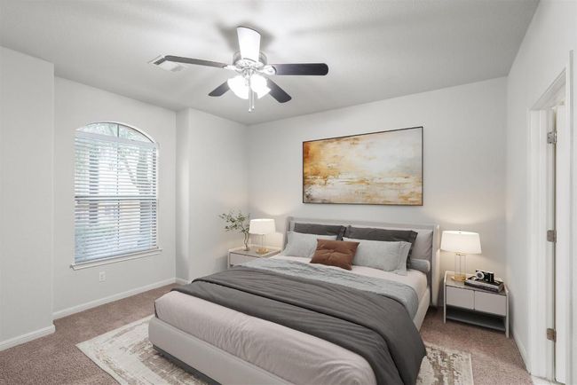 The primary bedroom suite with high ceiling, ceiling fan, and windows for natural light. | Image 5