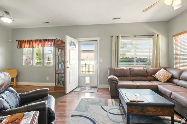 Living area with healthy amount of natural light, ceiling fan, and wood finished floors | Image 8