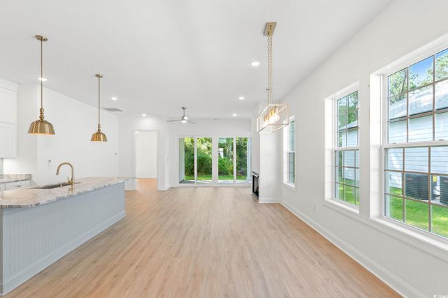 Kitchen featuring plenty of natural light, light wood-type flooring, white cabinets, and recessed lighting | Image 5