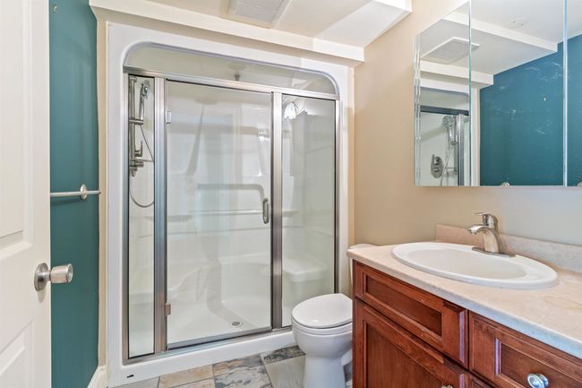 Full bathroom with visible vents, a stall shower, toilet, and vanity | Image 9