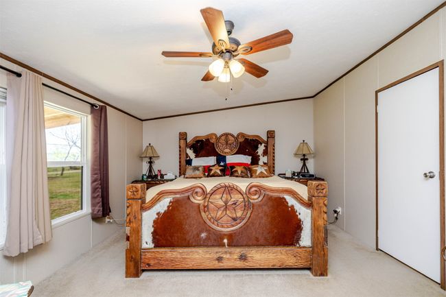 Bedroom with crown molding, light colored carpet, and ceiling fan | Image 19
