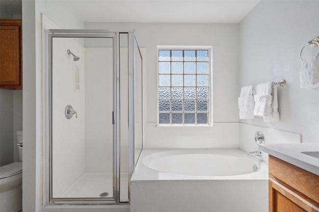 Full bath featuring vanity, a stall shower, a garden tub, and toilet | Image 24