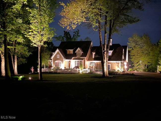 New England style home featuring a beautiful night lighting | Image 47
