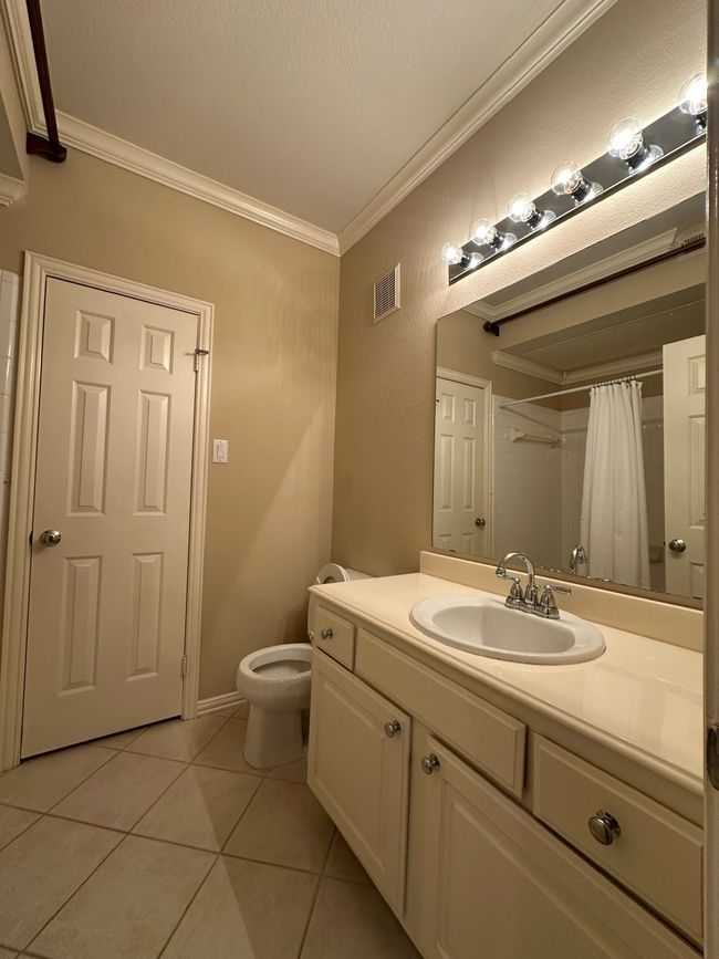Full bath with tile patterned flooring, vanity, crown molding, and a shower with curtain | Image 17