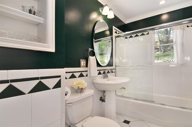 Bathroom with tile walls, toilet, enclosed tub / shower combo, ornamental molding, and tile patterned flooring | Image 11