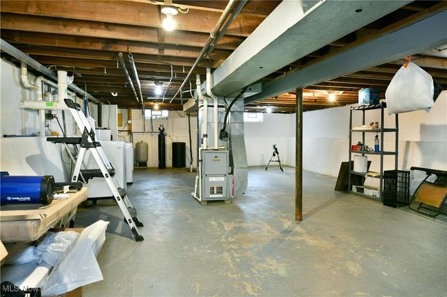 Basement featuring heating unit, washer / clothes dryer, and a water pressure tank | Image 35