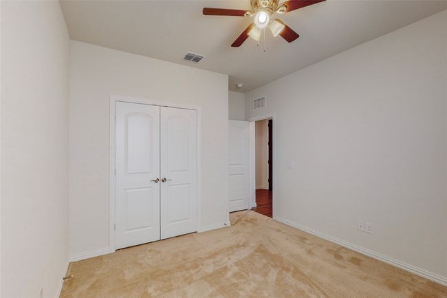 Unfurnished bedroom with carpet, a closet, baseboards, and a ceiling fan | Image 15