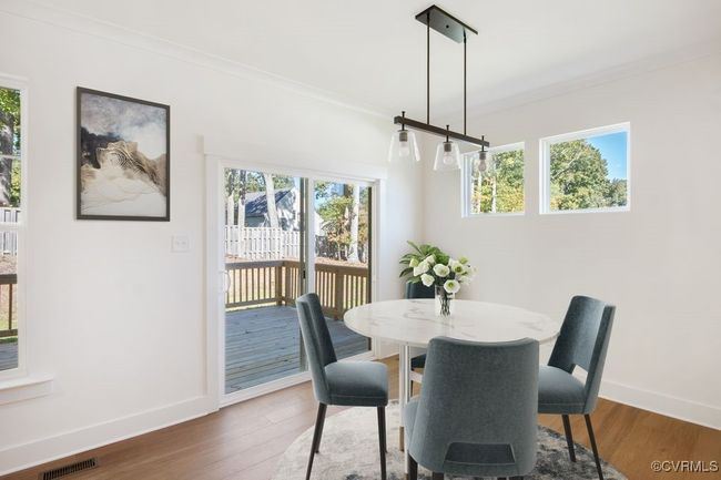 VIRTUAL STAGING. Photo represents the plan with virtual staging. A spacious kitchen with an island and pantry open to an adjoining dining area and the family room. | Image 12