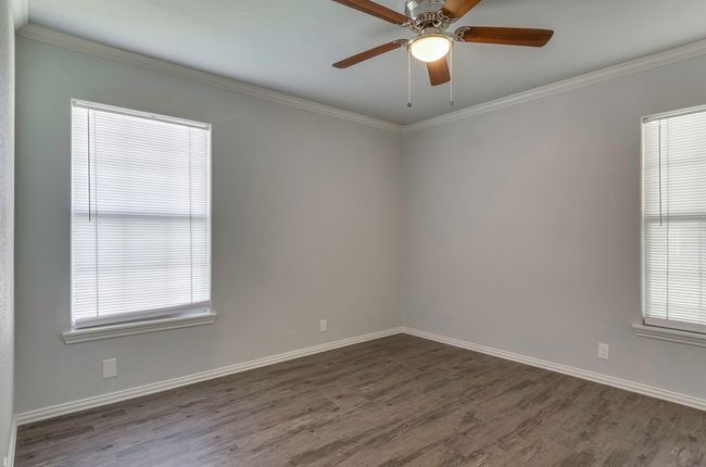 Spare room featuring dark wood-style floors, ornamental molding, and ceiling fan | Image 21