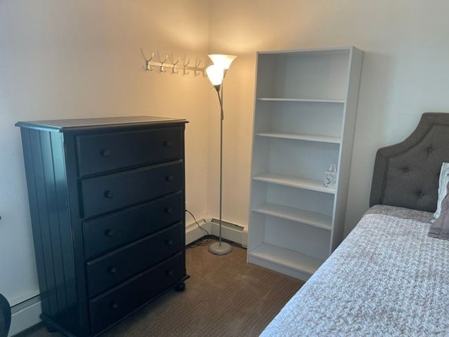 Bedroom with dark colored carpet and a baseboard heating unit | Image 8