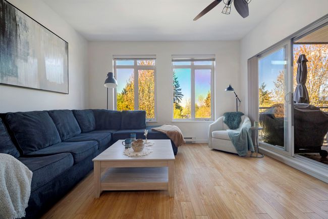 Living area with ceiling fan, a baseboard radiator, and light wood finished floors | Image 11
