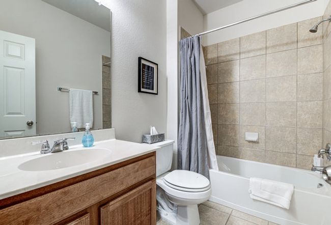 Bathroom featuring toilet, vanity, shower / tub combo with curtain, and tile patterned flooring | Image 16