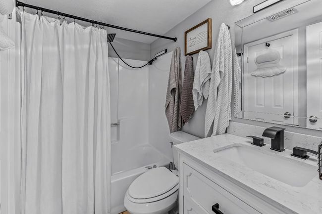 Bathroom with vanity, shower / bath combination with curtain, and toilet | Image 12