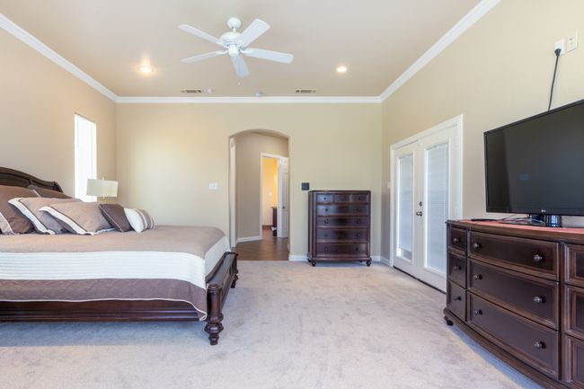 Bedroom featuring arched walkways, light carpet, ornamental molding, a ceiling fan, and recessed lighting | Image 22