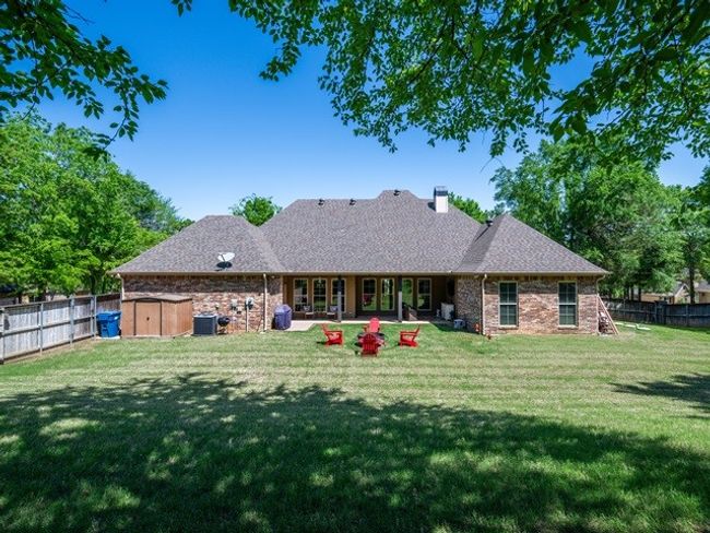 Rear view of property with a storage unit, a fenced backyard, a chimney, a patio area, and a yard | Image 37