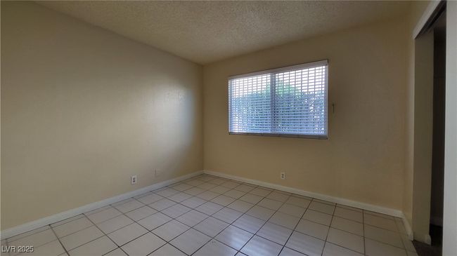 Spare room with a textured ceiling, light tile patterned floors, and baseboards | Image 9