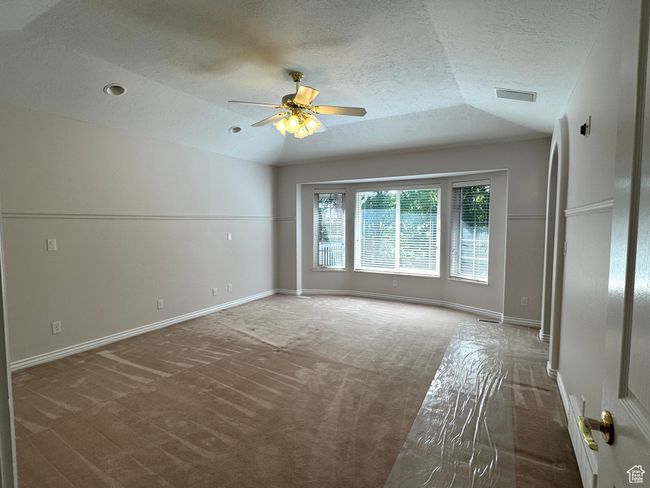 Primary bedroom with high ceiling, bay window and ceiling fan. | Image 13