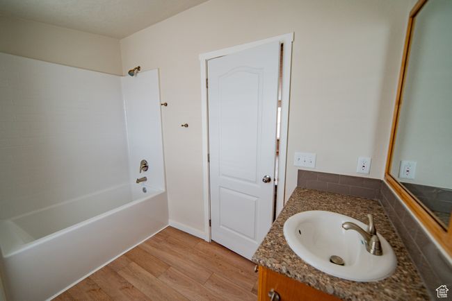 Bathroom featuring wood finished floors, vanity, and tub / shower combination | Image 34