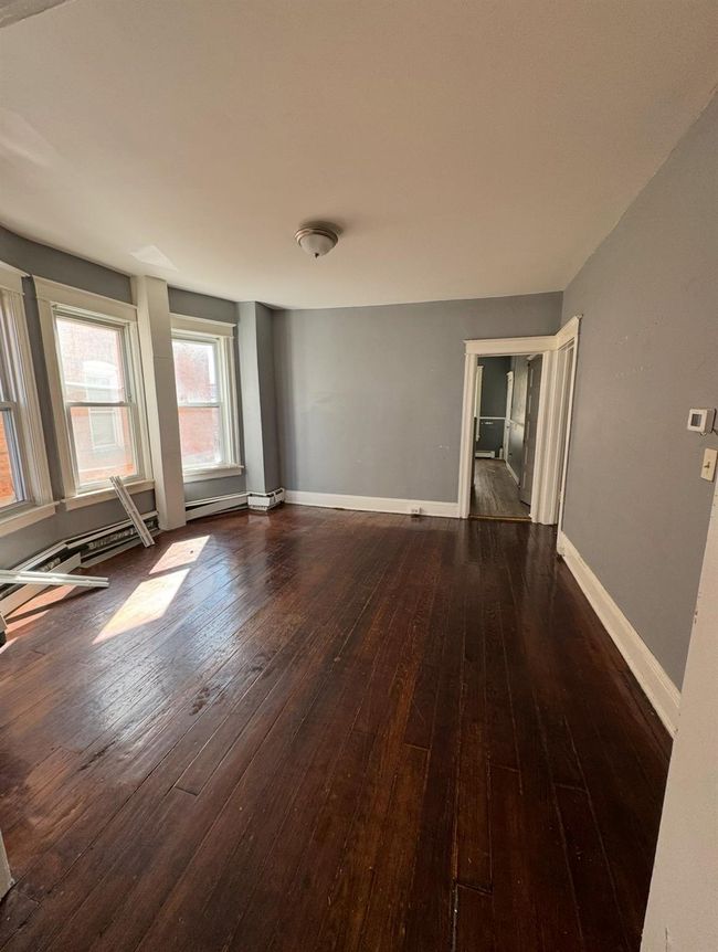 Spare room with baseboards and dark wood-style flooring | Image 5