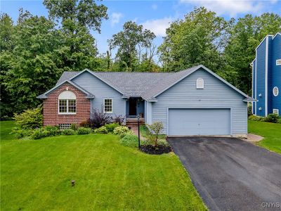 The driveway leads to the attached 2 car garage which provides one option to enter the home . . . or follow the brick paved walkway leading to the front door. | Image 2