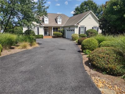 Cape cod house featuring a garage | Image 2