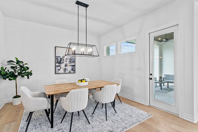 Dining space with light wood-style flooring and a chandelier | Image 11