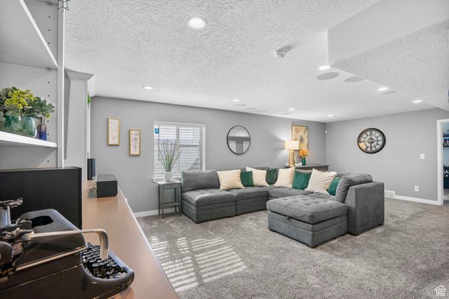 Carpeted living room featuring baseboards, a textured ceiling, and recessed lighting | Image 4