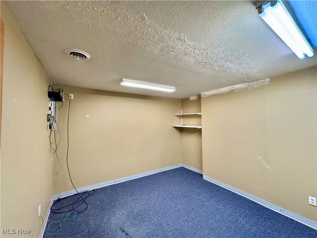 Basement with carpet flooring and a textured ceiling | Image 12