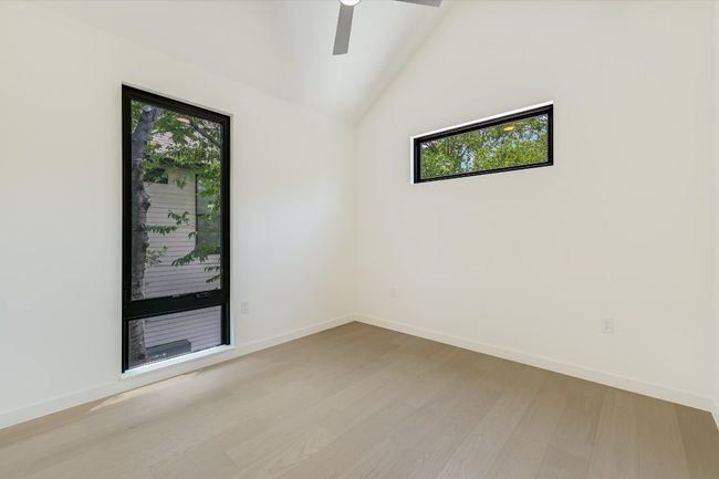 Unfurnished room featuring lofted ceiling, wood finished floors, and ceiling fan | Image 23