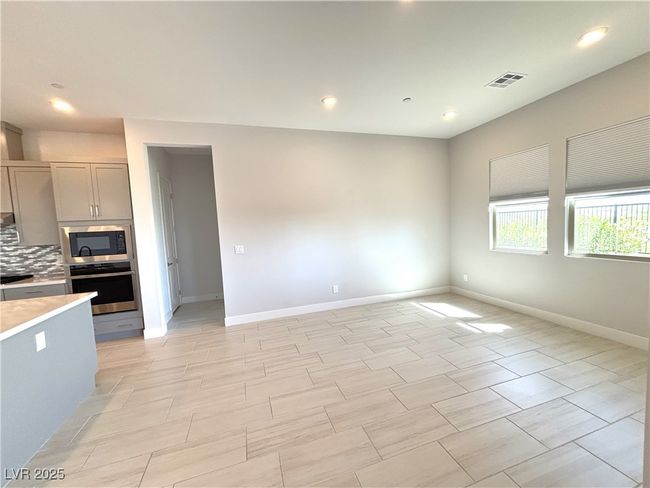 Kitchen with built in microwave, light countertops, visible vents, baseboards, and stainless steel oven | Image 10