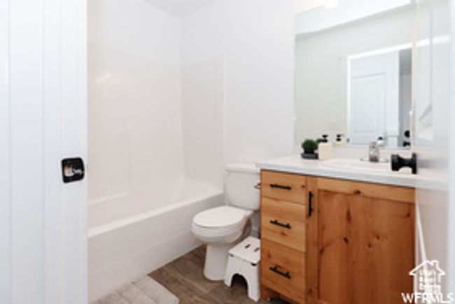 Full bath with vanity, toilet, wood finished floors, and shower combination | Image 21