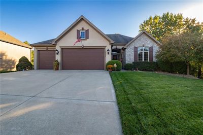 View of front of property featuring a front lawn and a garage | Image 1