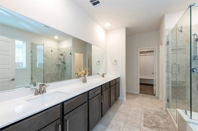 Full bathroom with a spacious closet, double vanity, a shower stall, and light tile patterned floors | Image 16