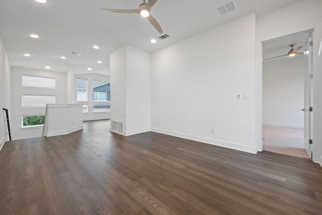 Unfurnished living room featuring a ceiling fan, dark wood-style flooring, and recessed lighting | Image 13