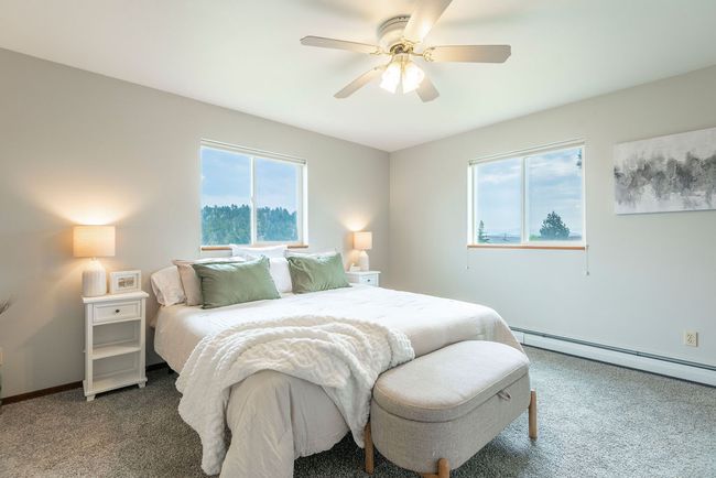 Bedroom with baseboard heating, carpet flooring, and a ceiling fan | Image 10